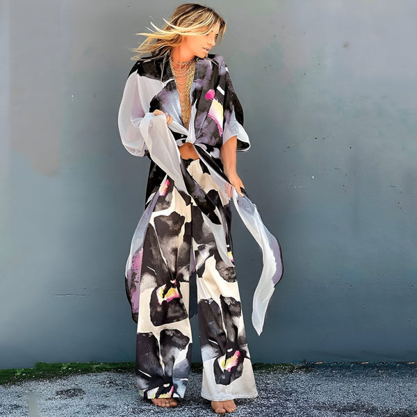 Femme portant un kimono imprimé et un pantalon assorti. Vêtements amples et fluides, style bohème chic. Collection de kimonos pour femmes.