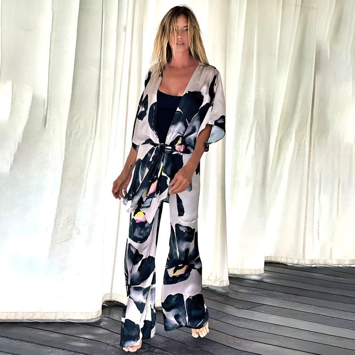 Femme portant un kimono et un pantalon assorti à motifs floraux noirs et blancs. Vêtements de style kimono disponibles à l'achat.