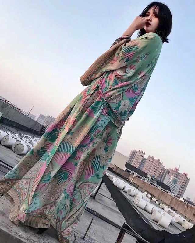 Femme portant un kimono long et fleuri, vue du ciel sur un toit d'immeuble en ville. Kimonos élégants à motifs floraux disponibles à l'achat. Découvrez notre collection de kimonos.