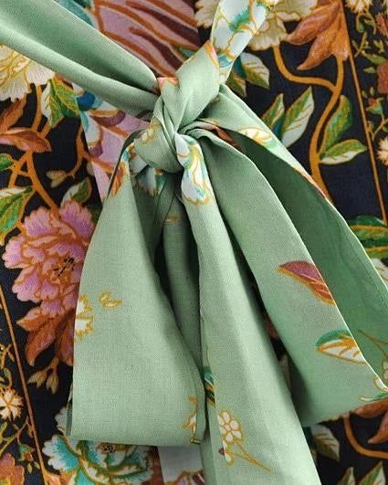 Détail du nœud d'un kimono à motifs floraux. Texture et couleurs vives d'un kimono, mettant en valeur la qualité des tissus et le design raffiné. Vêtements traditionnels japonais revisités pour la mode contemporaine.