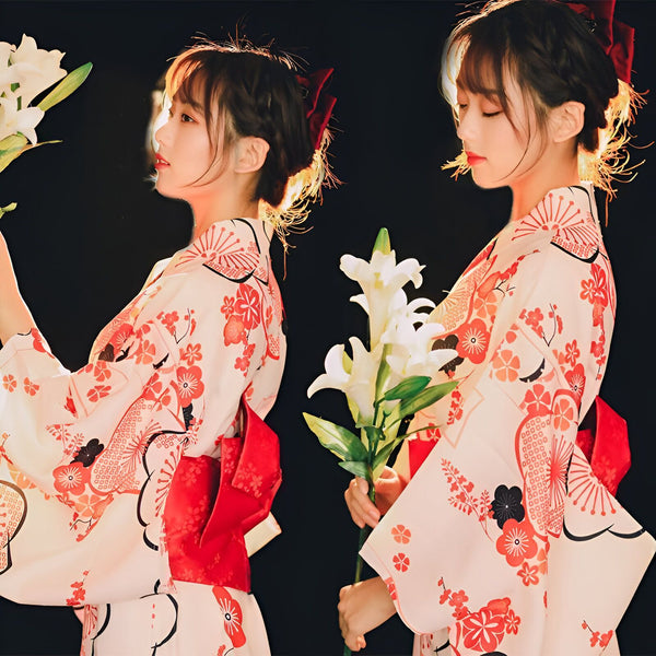 Deux femmes portant des kimonos fleuris, tenant des lys blancs. Découvrez notre collection de kimonos traditionnels et modernes. Vêtements japonais de qualité.