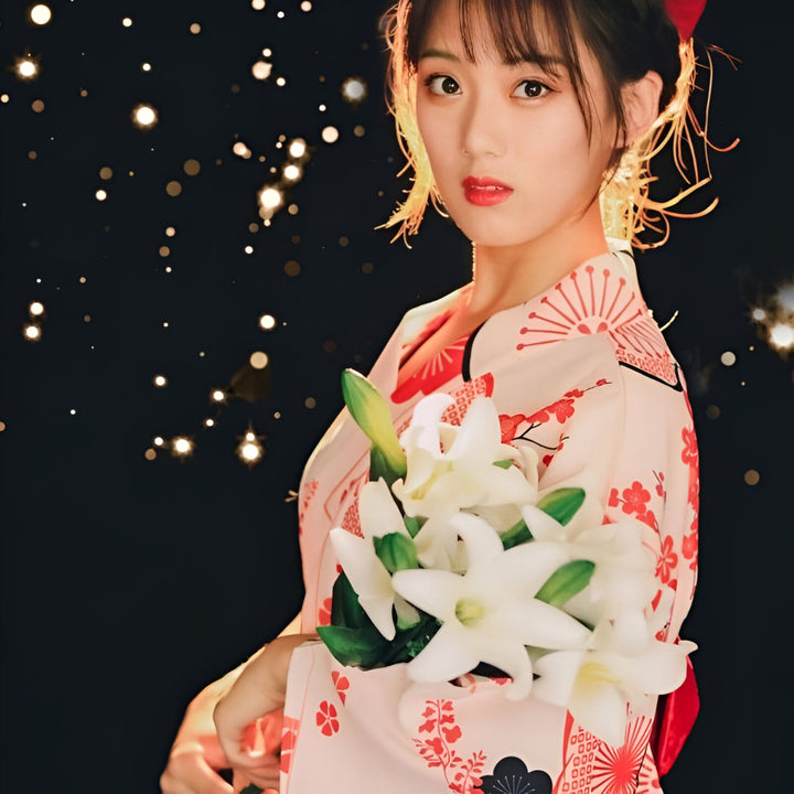 Femme en kimono traditionnel rose et rouge, tenant un bouquet de lys blancs. Fond noir avec des lumières scintillantes. Vente de kimonos authentiques.