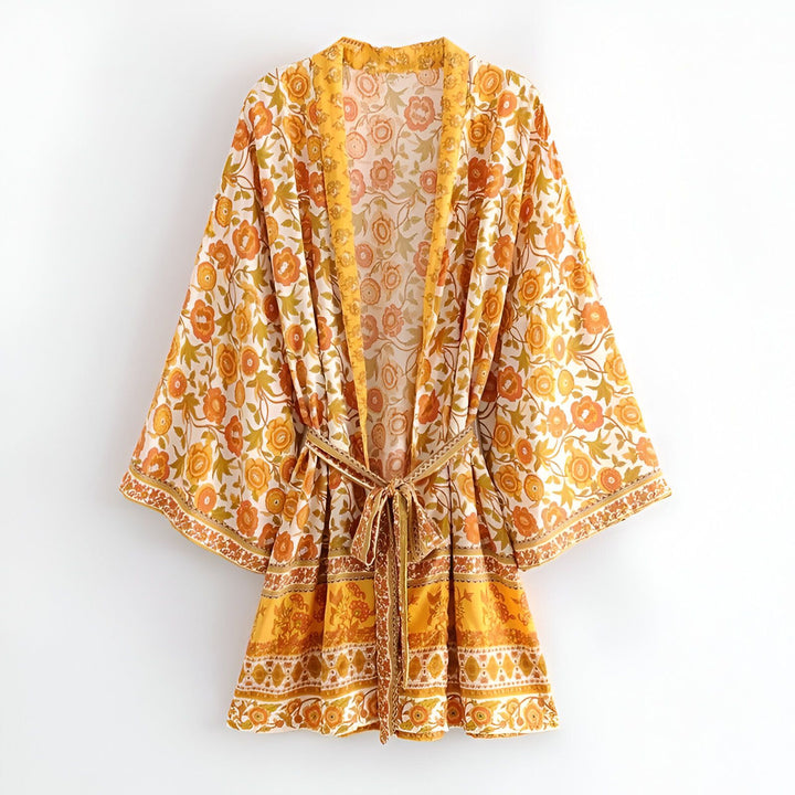 Kimono fleuri jaune et orange sur fond blanc. Vêtement style bohème avec ceinture. Idéal pour un look décontracté et élégant. Découvrez notre collection de kimonos uniques.