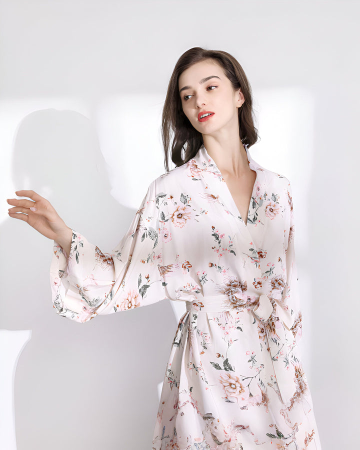 Femme portant un kimono fleuri blanc et rose. Vente de kimonos, motifs floraux, style japonais. Élégant, confortable et parfait pour la détente.