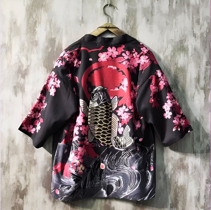 Kimono noir suspendu avec motif de carpe koï, fleurs de cerisier roses et soleil rouge. Style japonais traditionnel et élégant.