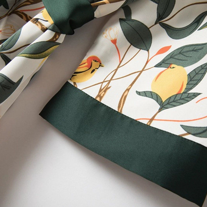 Détail d'un kimono avec motif floral, feuilles vertes, oiseaux et bordure vert foncé. Vêtement de style japonais en vente.