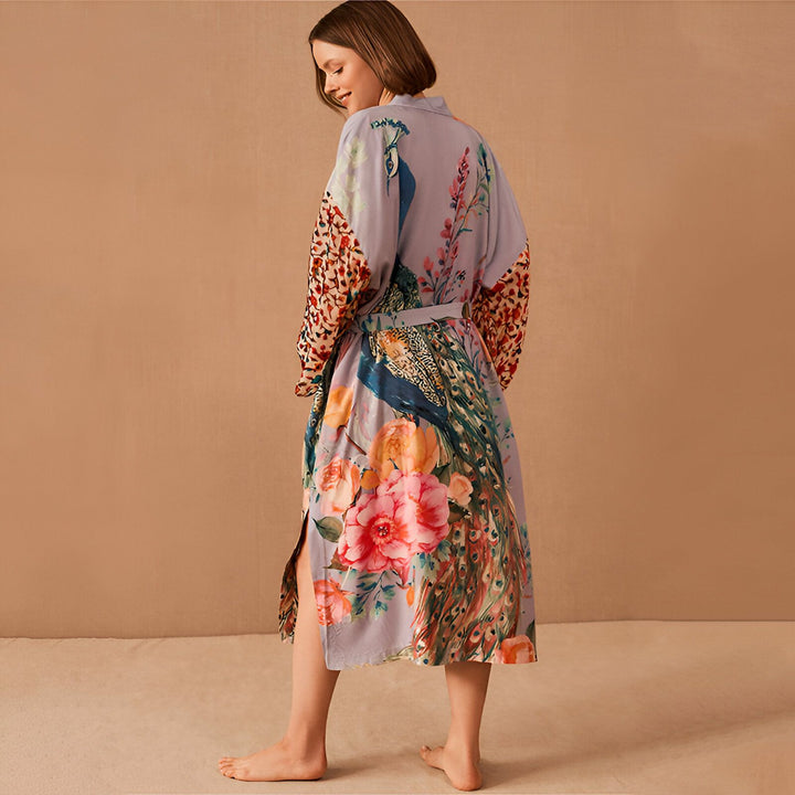 Femme portant un kimono imprimé floral et paon. Peignoir long avec ceinture, manches colorées. Vêtements d'intérieur élégants. Mode kimono.