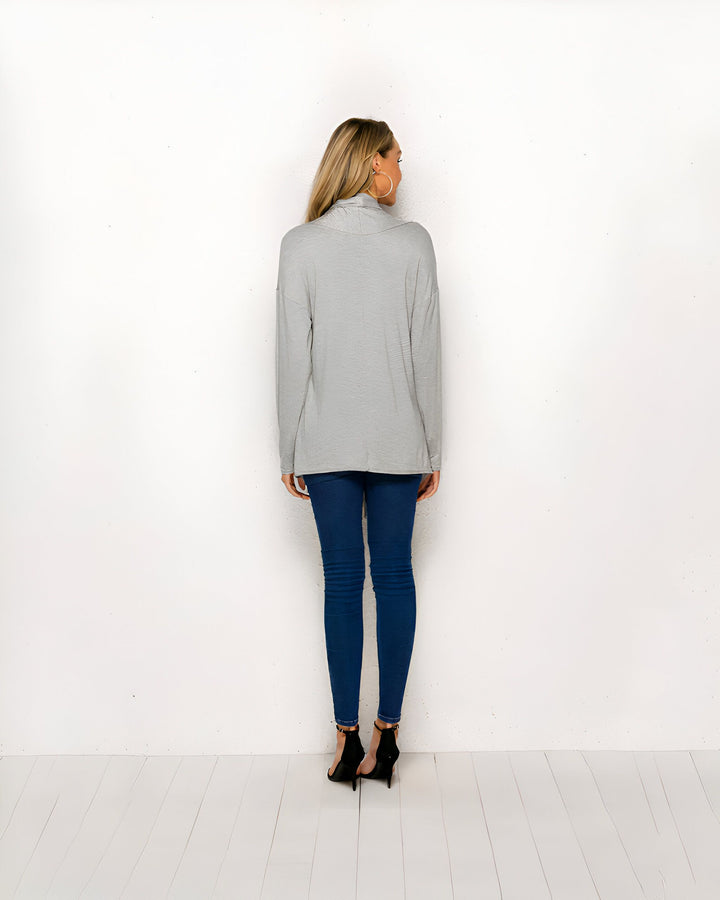 Femme portant un kimono gris, vue de dos. Elle porte un jean bleu et des talons noirs. Découvrez notre collection de kimonos uniques.