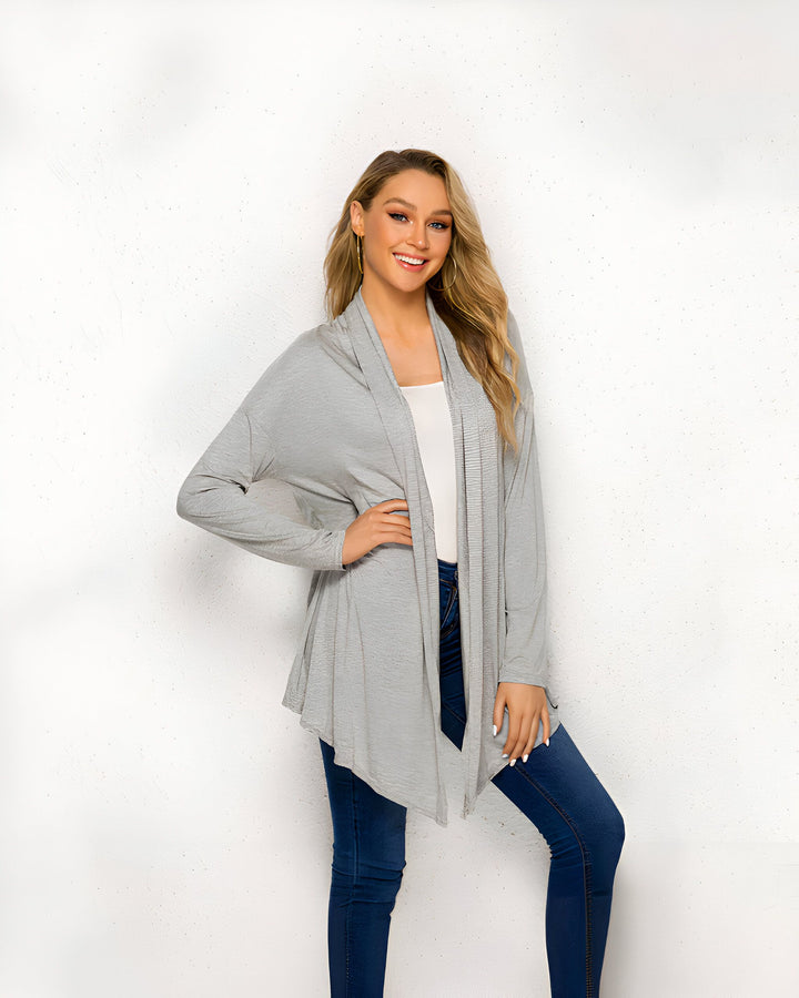 Femme souriante portant un kimono gris clair. Veste ample et décontractée, idéale pour compléter une tenue. Découvrez notre collection de kimonos pour femmes.