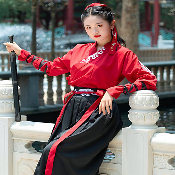 Femme en kimono rouge et noir tenant un katana. Vêtements traditionnels japonais en vente. Kimonos de qualité et accessoires authentiques. Découvrez notre collection.