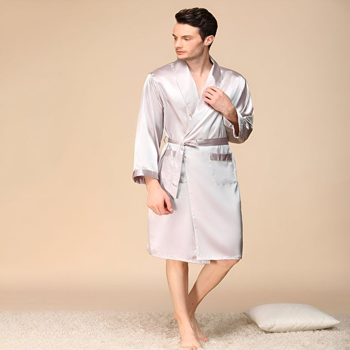 Homme portant un kimono de satin gris avec ceinture. Vêtements d'intérieur élégants, peignoir confortable. Découvrez notre collection de kimonos de luxe.