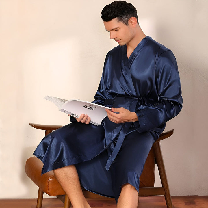 Homme lisant un livre, portant un kimono bleu marine. Vente de kimonos de luxe pour hommes et femmes. Peignoirs kimono confortables et élégants.