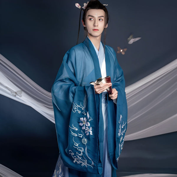 Homme portant un kimono bleu brodé avec des motifs floraux, tenant un éventail. Vêtements traditionnels asiatiques en vente.