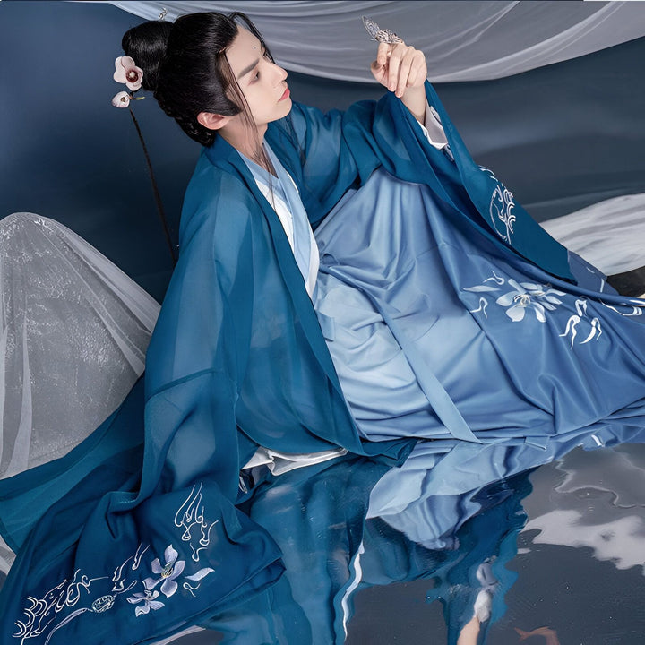 Homme portant un kimono bleu avec des motifs floraux blancs, coiffure traditionnelle. Vêtements japonais traditionnels en vente.