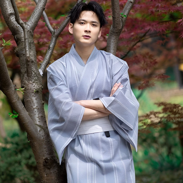 Homme portant un kimono gris à rayures. Vente de kimonos pour hommes et femmes. Style japonais traditionnel. Mode ethnique et élégance.