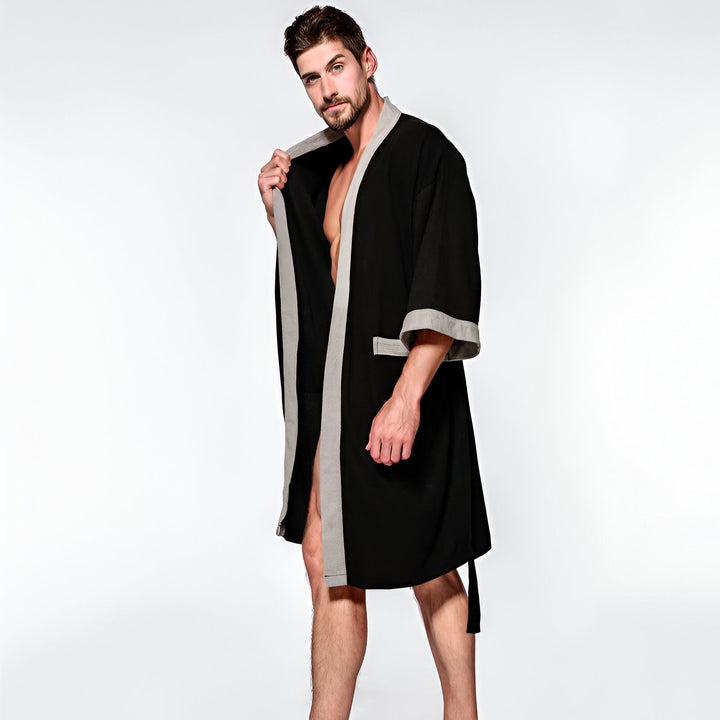 Homme portant un kimono noir avec des bordures grises. Kimonos pour hommes disponibles à l'achat.