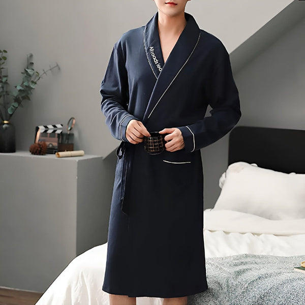 Homme portant un kimono bleu marine avec une tasse à la main. Vente de kimonos pour hommes et femmes. Pyjamas japonais traditionnels et modernes.