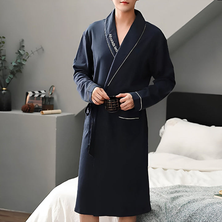 Homme portant un kimono bleu marine avec une tasse à la main. Vente de kimonos pour hommes et femmes. Pyjamas japonais traditionnels et modernes.