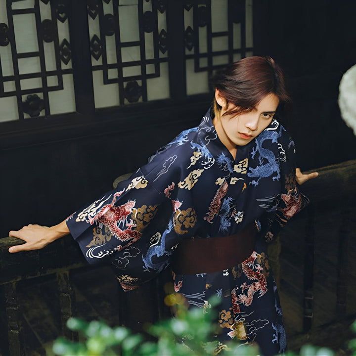 Homme portant un kimono bleu marine à motifs de dragons et de nuages, regardant la caméra. Kimono traditionnel japonais, disponible à l'achat. Mode asiatique.