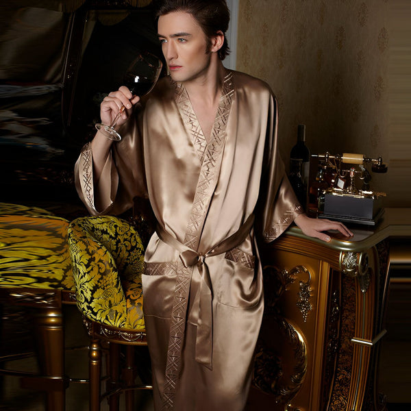 Homme élégant en kimono en soie champagne, tenant un verre de vin rouge. Kimonos de luxe pour hommes, vêtements d'intérieur chics et confortables. Découvrez notre collection de kimonos.