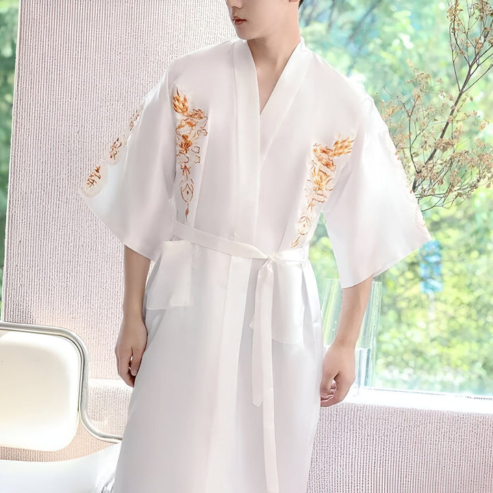 Homme portant un kimono blanc avec des broderies de dragons dorés. Kimono japonais traditionnel avec ceinture. Vêtements japonais authentiques.