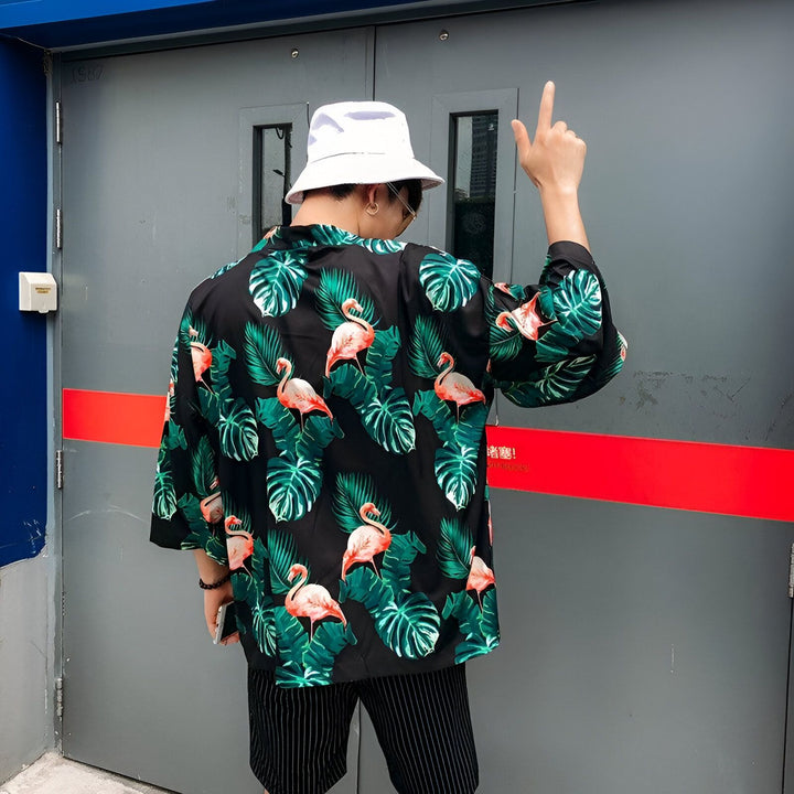 Homme portant un kimono à motifs flamants roses et feuilles tropicales, style décontracté. Collection de kimonos originaux.