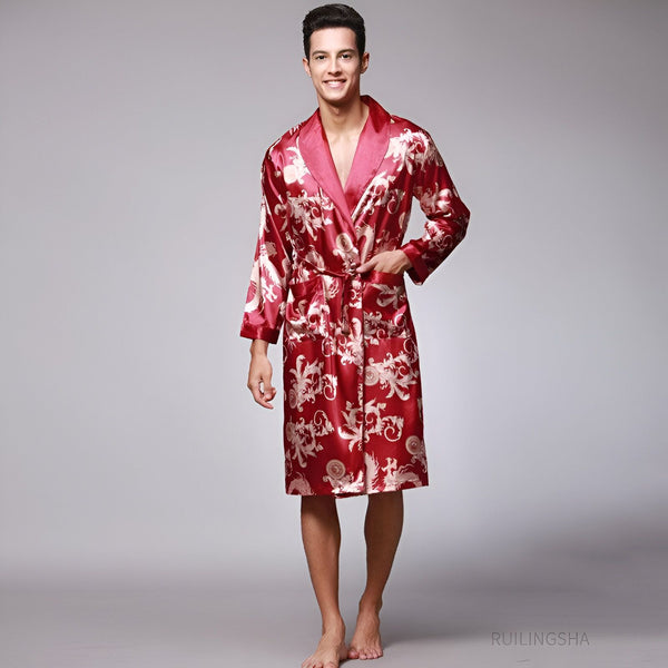 Homme souriant portant un kimono rouge en satin avec motifs floraux dorés. Vente de kimonos traditionnels et modernes pour hommes.