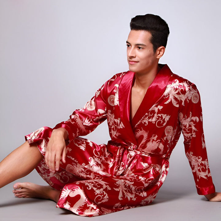 Homme portant un kimono rouge en satin avec motifs de dragons dorés. Élégant peignoir japonais à la mode, idéal pour la détente à la maison. Kimonos en vente sur notre site.