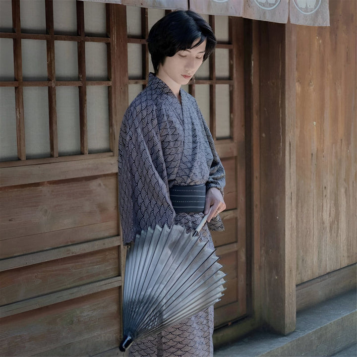 Homme portant un kimono traditionnel japonais avec un motif de vagues, tenant un éventail. Vêtements japonais traditionnels en vente.
