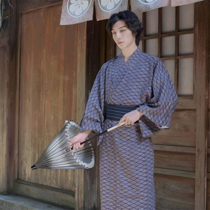 Homme portant un kimono japonais traditionnel avec motifs. Vente de kimonos authentiques en ligne. Kimono homme avec obi noire et ombrelle assortie. Découvrez notre collection unique de kimonos.