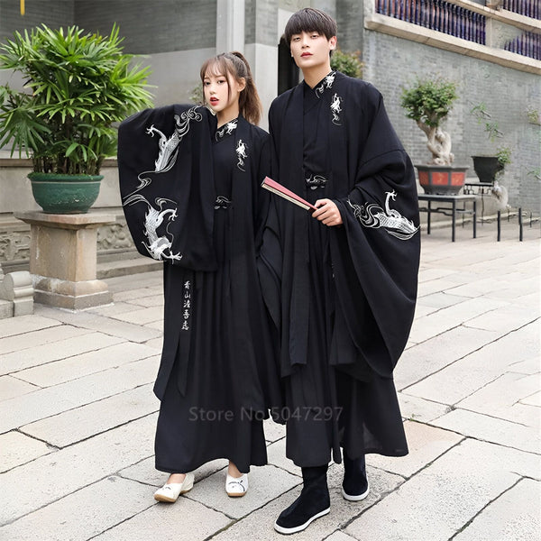 Couple portant des kimonos noirs brodés. Vêtements traditionnels japonais, robes amples avec motifs de dragons blancs. Mode asiatique, vente de kimonos authentiques.