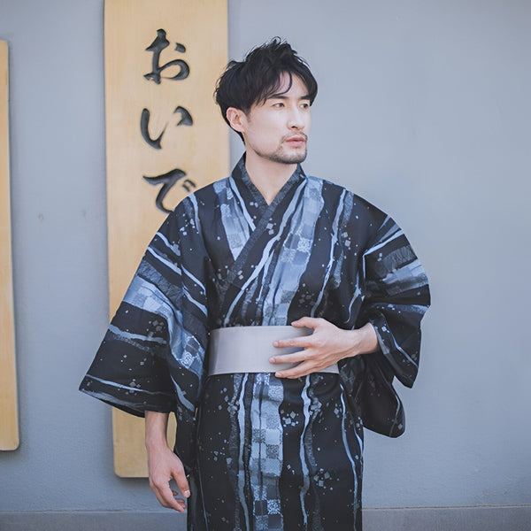 Homme portant un kimono japonais traditionnel avec motifs noirs et bleus. Découvrez notre collection de kimonos authentiques.