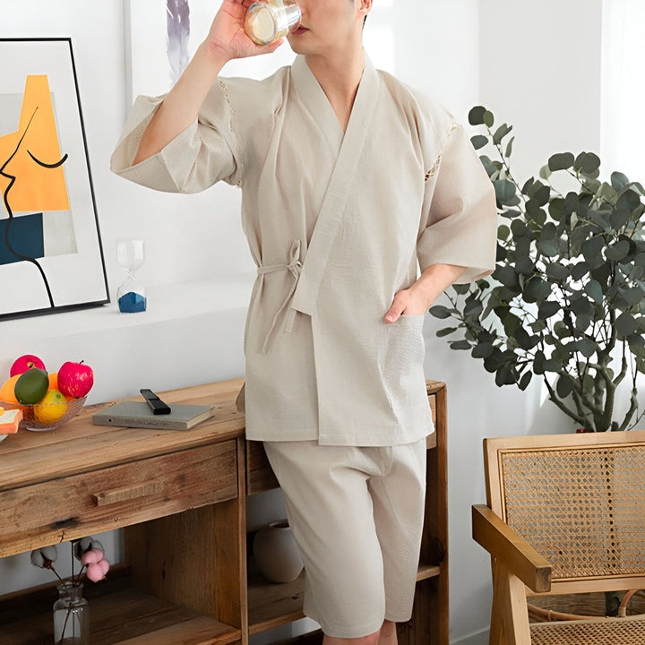 Homme portant un kimono beige et buvant. Kimonos en vente.
