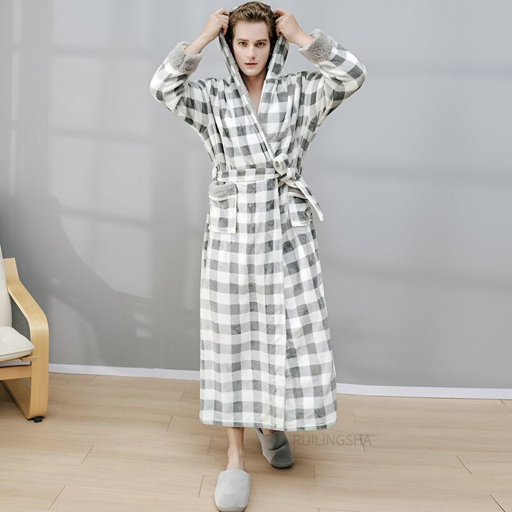 Homme portant un kimono long à carreaux gris et blancs avec capuche et ceinture. Idéal comme peignoir confortable. Découvrez notre collection de kimonos de qualité.