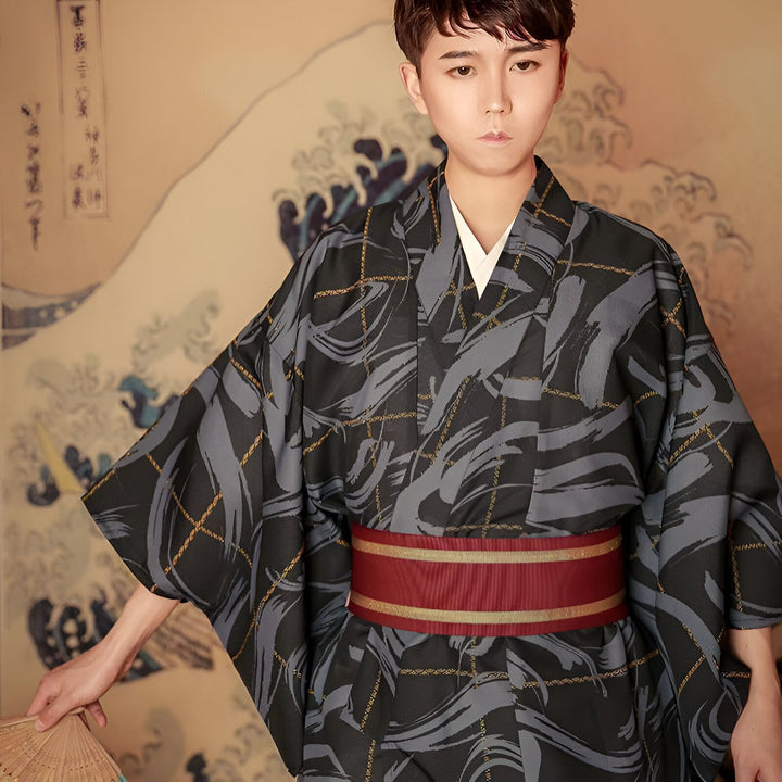 Homme portant un kimono traditionnel japonais à motifs gris et noirs, avec une ceinture rouge et or. Kimono pour hommes. Vêtements traditionnels japonais.