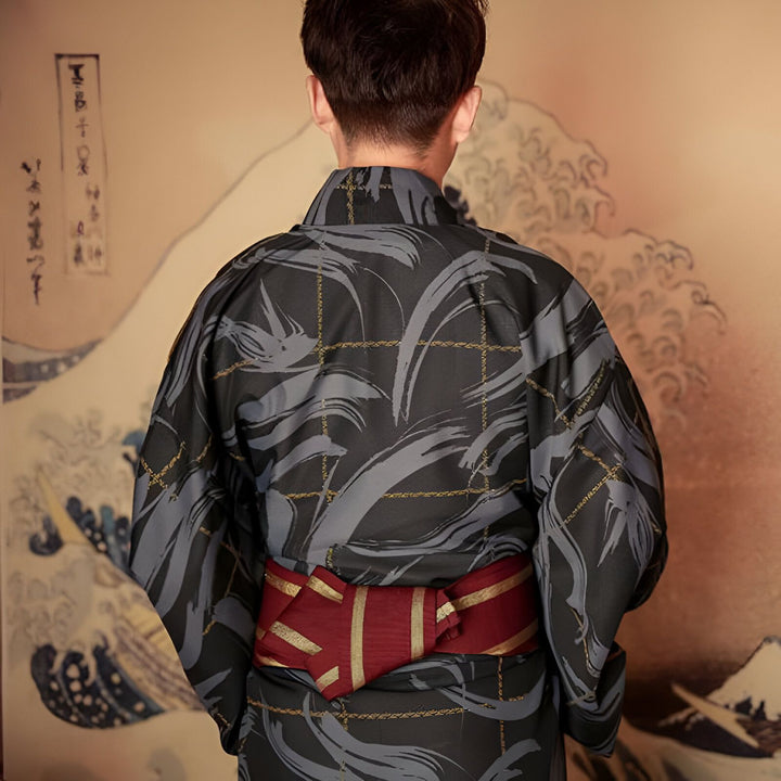 Homme portant un kimono traditionnel japonais noir et gris avec une ceinture rouge et or. Vêtement japonais authentique en vente.