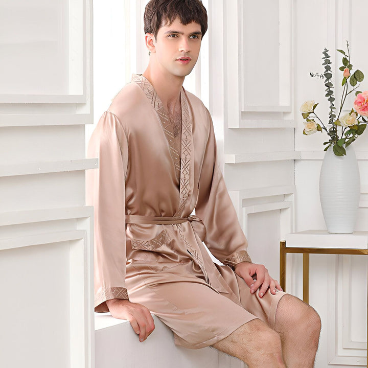 Homme portant un kimono court couleur champagne, avec motifs décoratifs sur les revers et les manches. Ceinture assortie. Kimono idéal pour la détente.