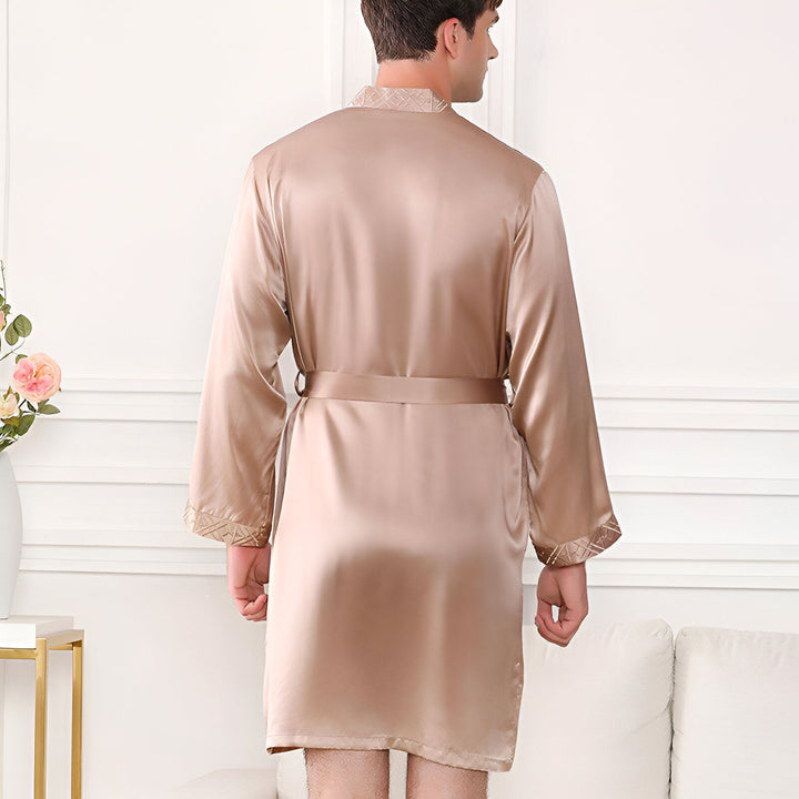 Homme vu de dos portant un kimono en soie beige. Kimono élégant avec ceinture et motifs décoratifs au col et aux manches. Vêtements de détente, peignoir de luxe. Collection de kimonos.