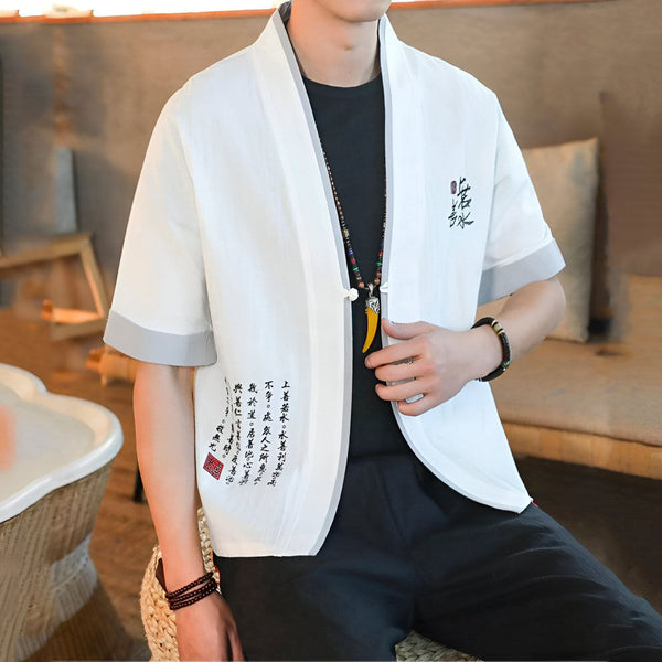Homme portant un kimono blanc à manches courtes avec des détails gris et des inscriptions calligraphiques. Vêtement de style japonais, idéal pour un look tendance et décontracté. Découvrez notre collection de kimonos uniques.