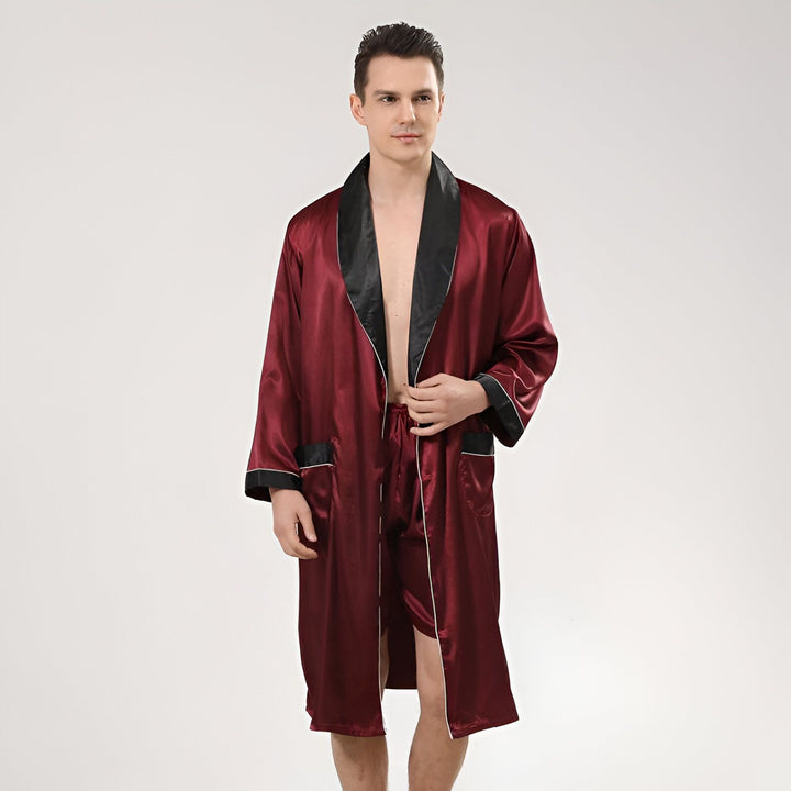 Homme portant un kimono bordeaux en satin avec bordure noire. Vêtement d'intérieur élégant et confortable. Kimonos pour hommes disponibles.