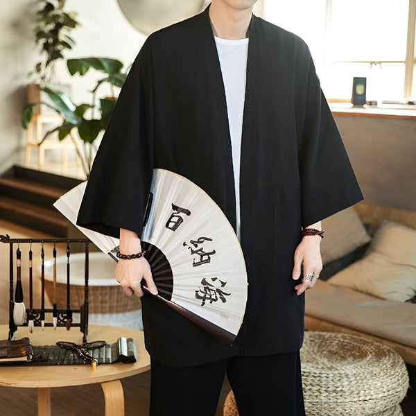 Homme portant un kimono noir avec un éventail. Kimono traditionnel japonais à manches larges. Découvrez notre collection de kimonos pour hommes et femmes.