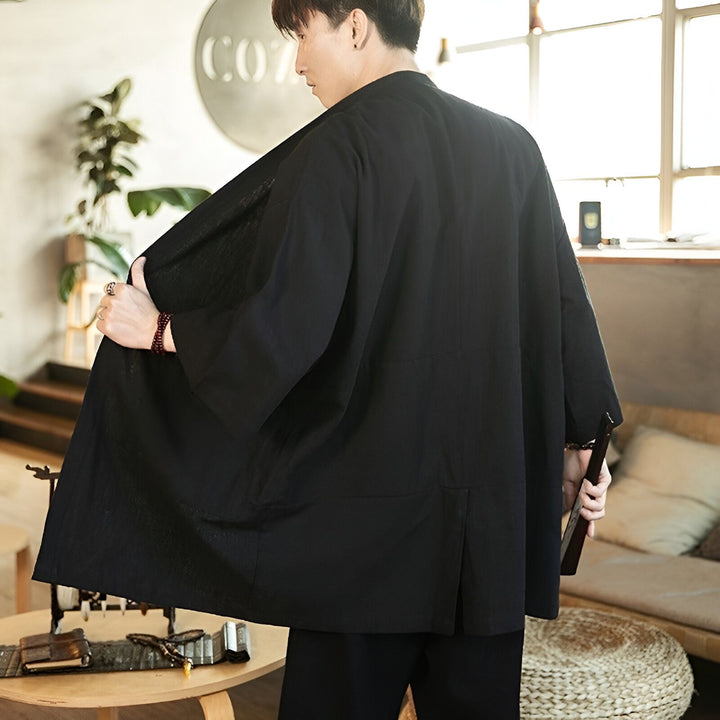 Homme portant un kimono noir traditionnel. Vente de kimonos japonais pour hommes et femmes. Découvrez notre collection unique de kimonos et vestes de style japonais.