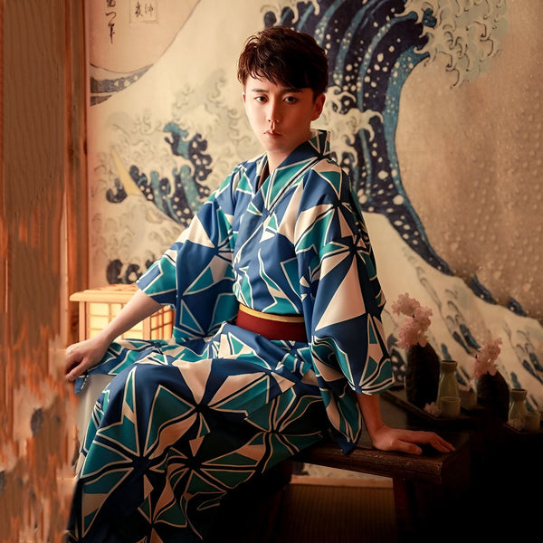 Homme portant un kimono japonais bleu à motifs géométriques, avec une ceinture rouge. Kimono traditionnel à vendre sur notre site. Arrière-plan avec une estampe de la vague d'Hokusai.