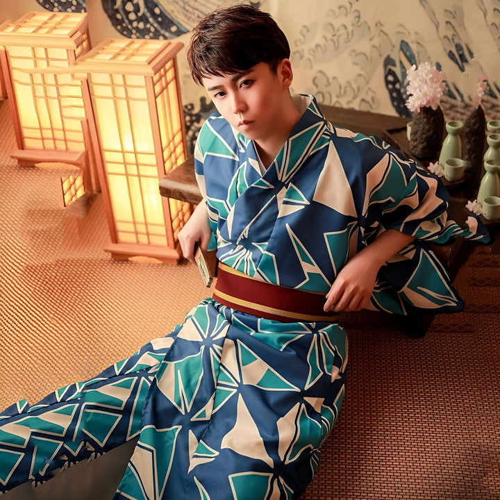 Homme en kimono bleu et blanc avec motif géométrique, ceinture rouge. Lanternes japonaises et décor traditionnel en arrière-plan. Vente de kimonos authentiques.