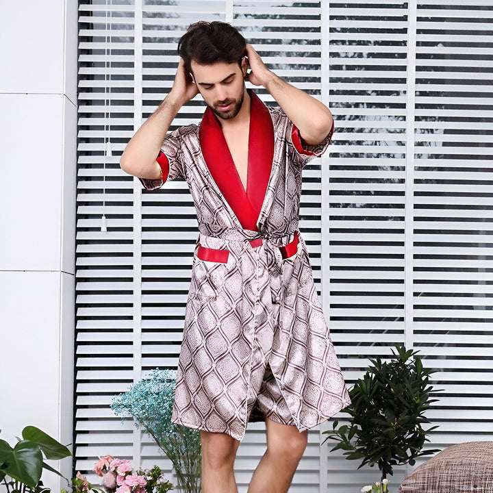 Homme portant un kimono de style peignoir avec motif ornemental et col rouge. Idéal comme vêtement d'intérieur ou cadeau. Découvrez notre collection de kimonos pour hommes.