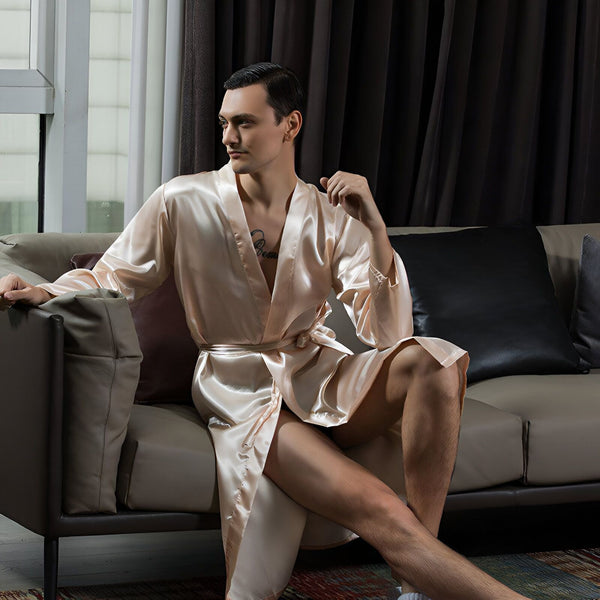 Homme portant un kimono en satin couleur champagne assis sur un canapé. Vente de kimonos homme.