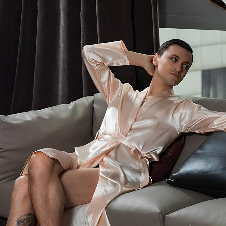 Homme portant un kimono rose en soie, assis sur un canapé. Vêtements de détente élégants. Nouveau style de kimono.