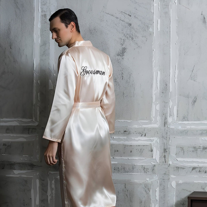 Homme portant un kimono rose personnalisé avec le mot "Groomsman" brodé. Kimonos élégants pour mariages et événements spéciaux.