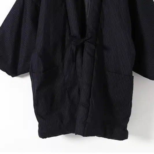 Kimono homme noir à rayures, vendu en ligne. Vêtement traditionnel japonais avec manches larges et ceinture nouée. Idéal pour un style unique et élégant.