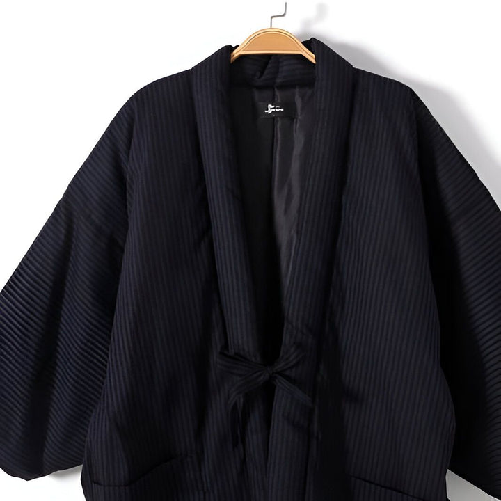Kimono à rayures noires, suspendu sur un cintre. Vêtements de style japonais, amples et confortables. Découvrez notre collection unique de kimonos.